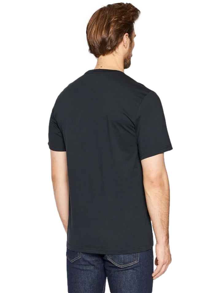 Hombre vistiendo playera negra de manga corta con estampado gráfico colorido en el pecho de la marca Converse.