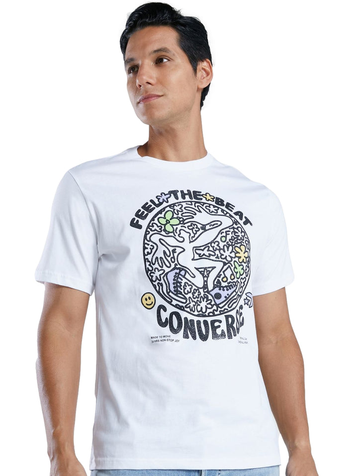 Hombre vistiendo playera blanca de manga corta marca Converse con estampado gráfico circular en el pecho.