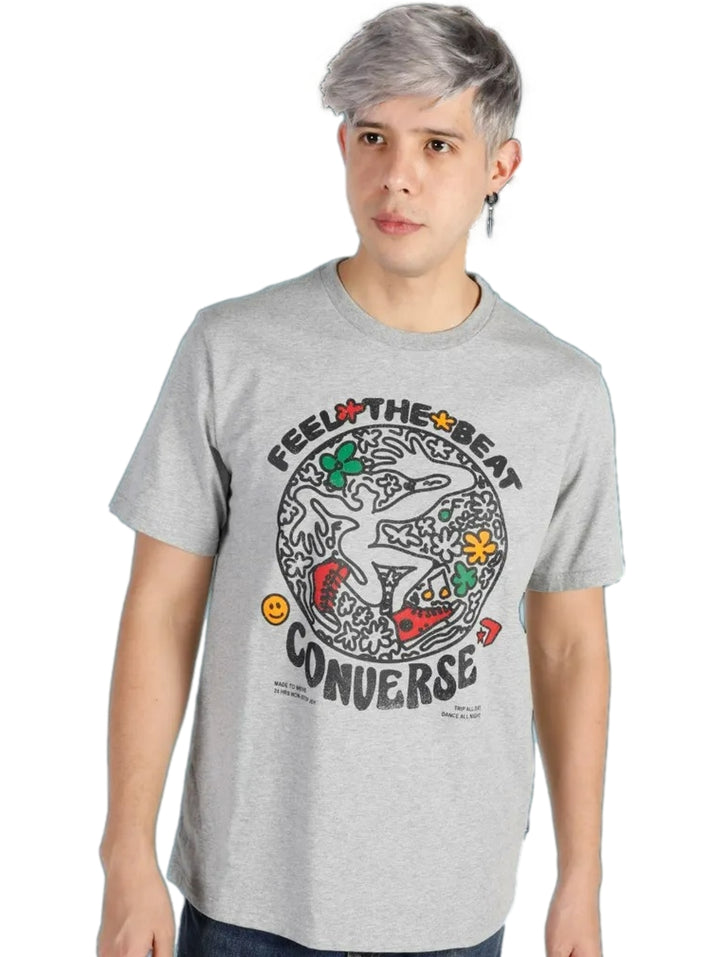 Hombre vistiendo playera Converse color gris jaspeado con estampado gráfico colorido en el pecho.