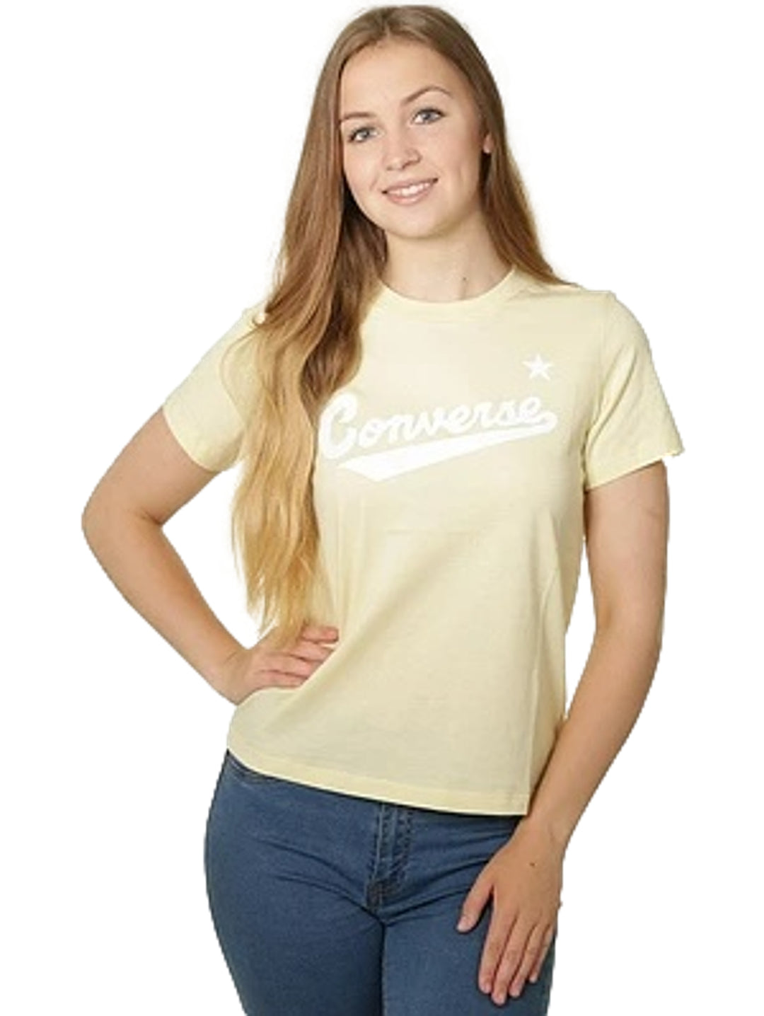 Mujer vistiendo playera Converse color amarillo limón con logotipo blanco en el pecho y jeans azules.