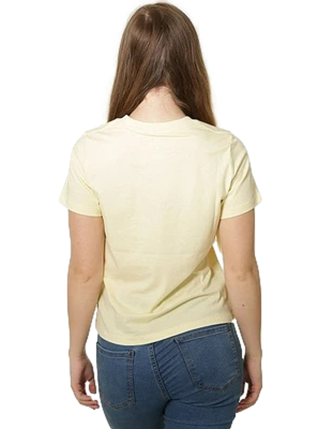 Mujer vistiendo playera Converse color amarillo limón con logotipo blanco en el pecho y jeans azules.