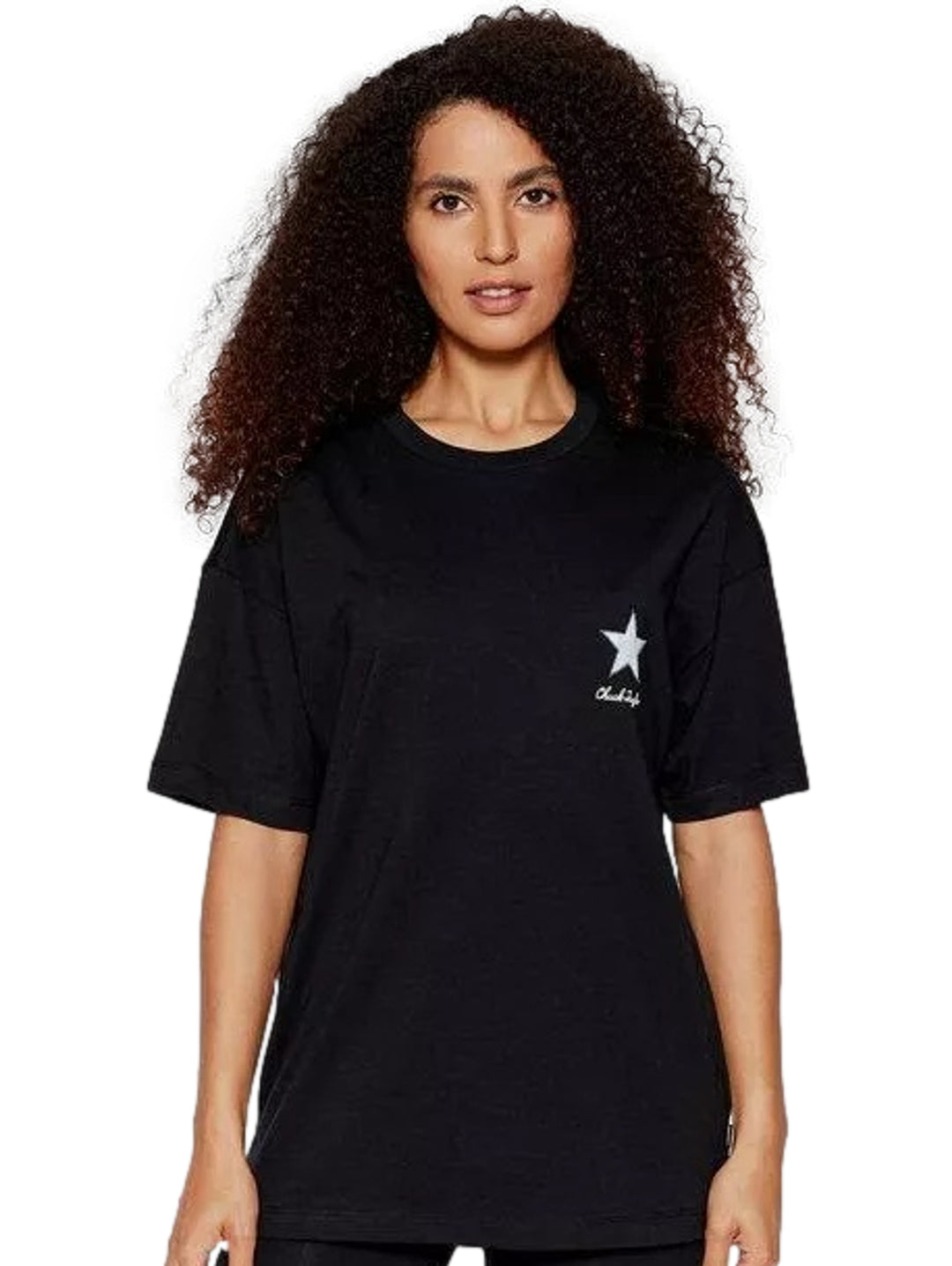 Mujer vistiendo playera negra de manga corta marca Converse con un pequeño logotipo de estrella blanca en el pecho.