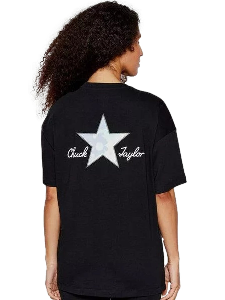 Mujer vistiendo playera negra de manga corta marca Converse con un pequeño logotipo de estrella blanca en el pecho.