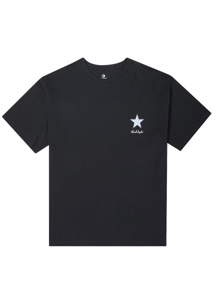 Mujer vistiendo playera negra de manga corta marca Converse con un pequeño logotipo de estrella blanca en el pecho.