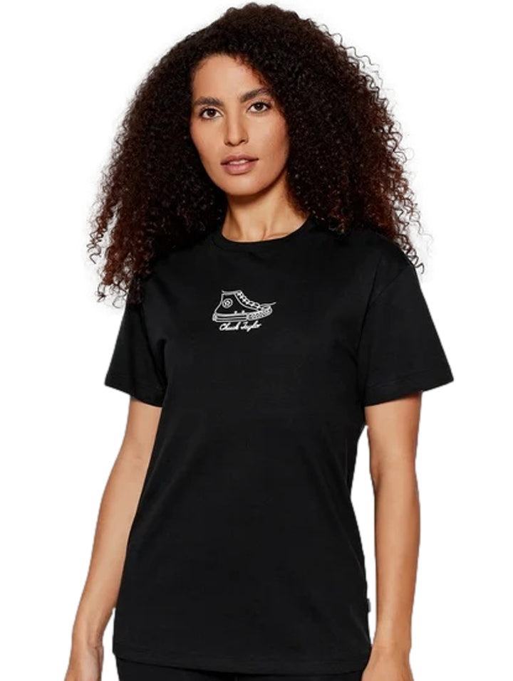 Mujer vistiendo playera negra de manga corta con estampado blanco de zapato Converse en el pecho.
