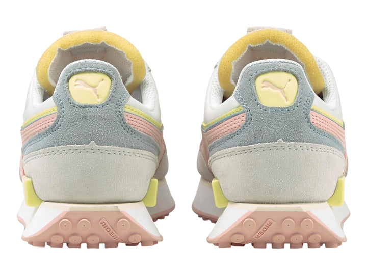 Tenis PUMA blancos con detalles en tonos pastel rosa, amarillo y gris, con suela blanca.