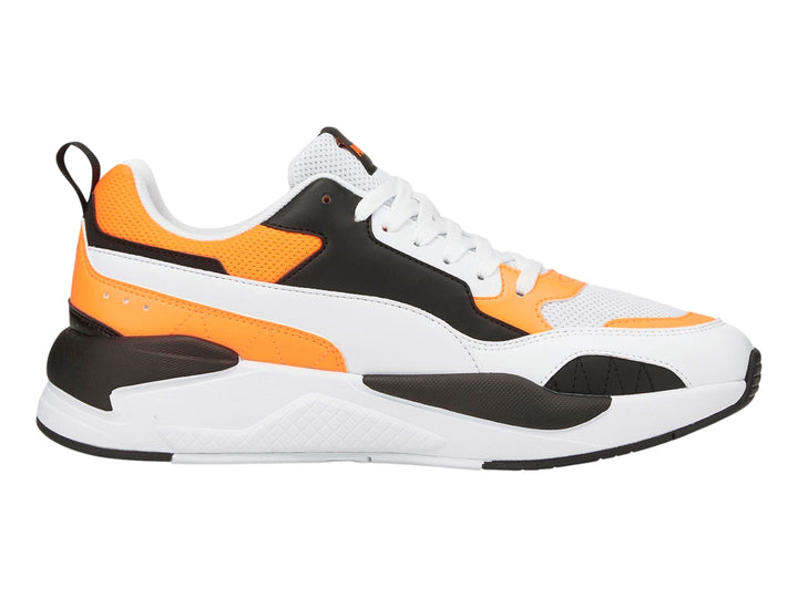 Tenis deportivos PUMA en color blanco con detalles en naranja fluorescente y negro.