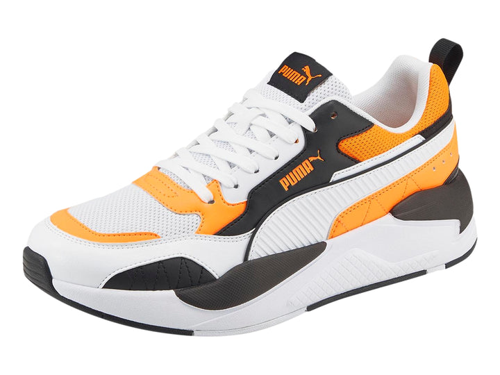 Tenis deportivos PUMA en color blanco con detalles en naranja fluorescente y negro.