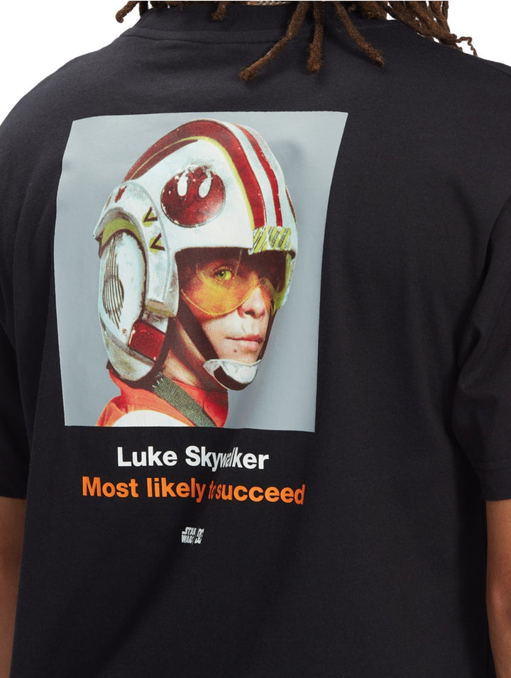 Vista posterior de camiseta negra con gráfico de Luke Skywalker y texto en la espalda.