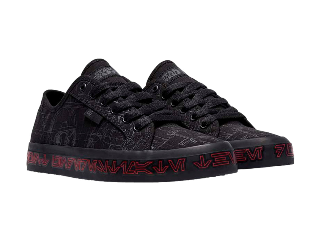 Tenis negros DC Shoes con gráficos grises y letras rojas en la suela.