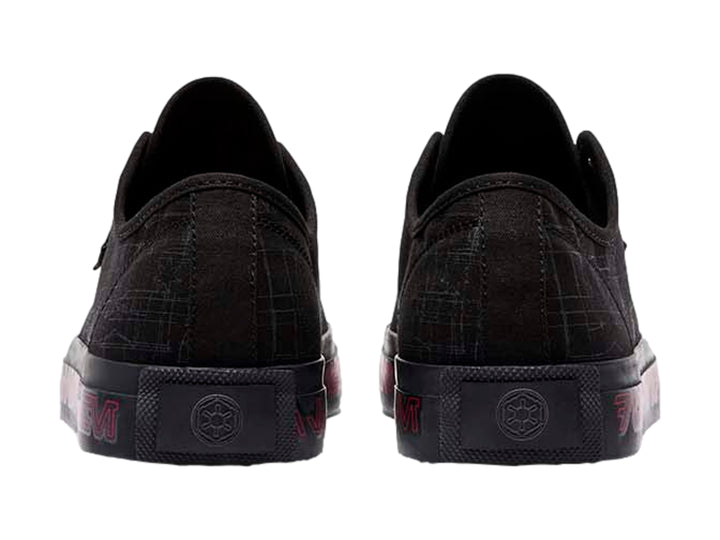 Tenis negros DC Shoes con gráficos grises y letras rojas en la suela.