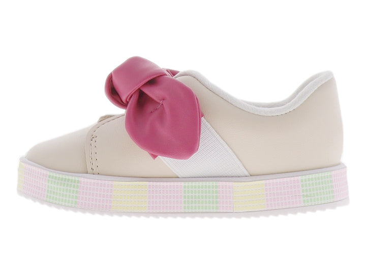 Zapato infantil color crema con un gran moño rosa en la parte superior y suela de plataforma con patrón cuadriculado.