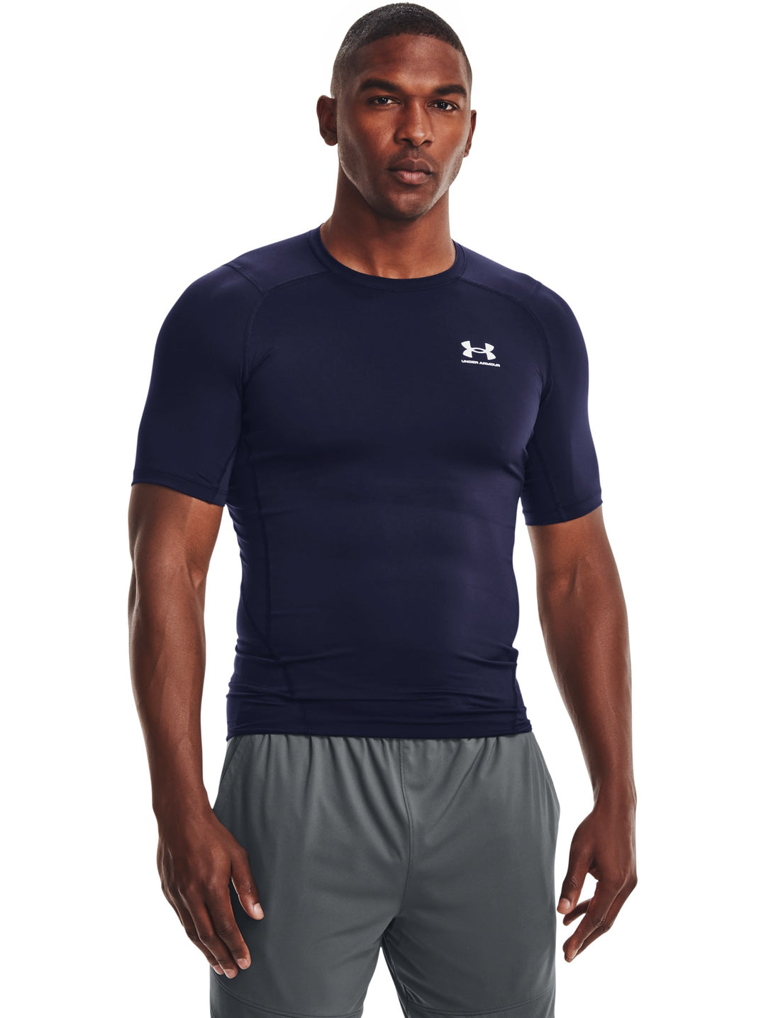 Hombre vistiendo una camiseta de compresión Under Armour de color azul marino y manga corta.