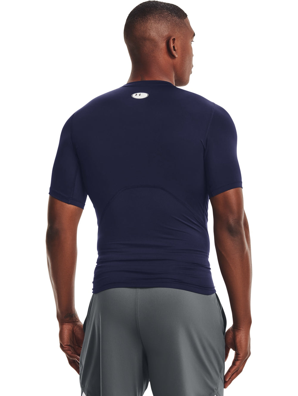 Hombre vistiendo una camiseta de compresión Under Armour de color azul marino y manga corta.