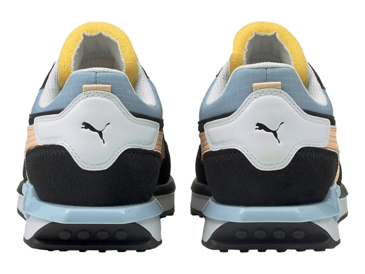 Tenis PUMA negro con franja color durazno, detalles en azul claro y suela blanca.