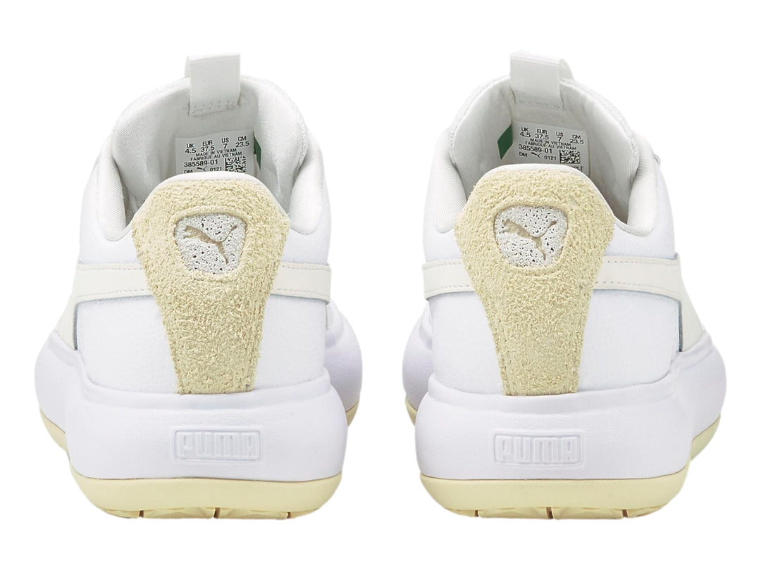 Tenis PUMA blancos de plataforma con detalle en gamuza beige en el talón.