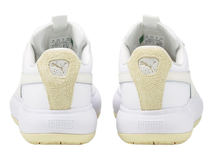 Tenis PUMA blancos de plataforma con detalle en gamuza beige en el talón.