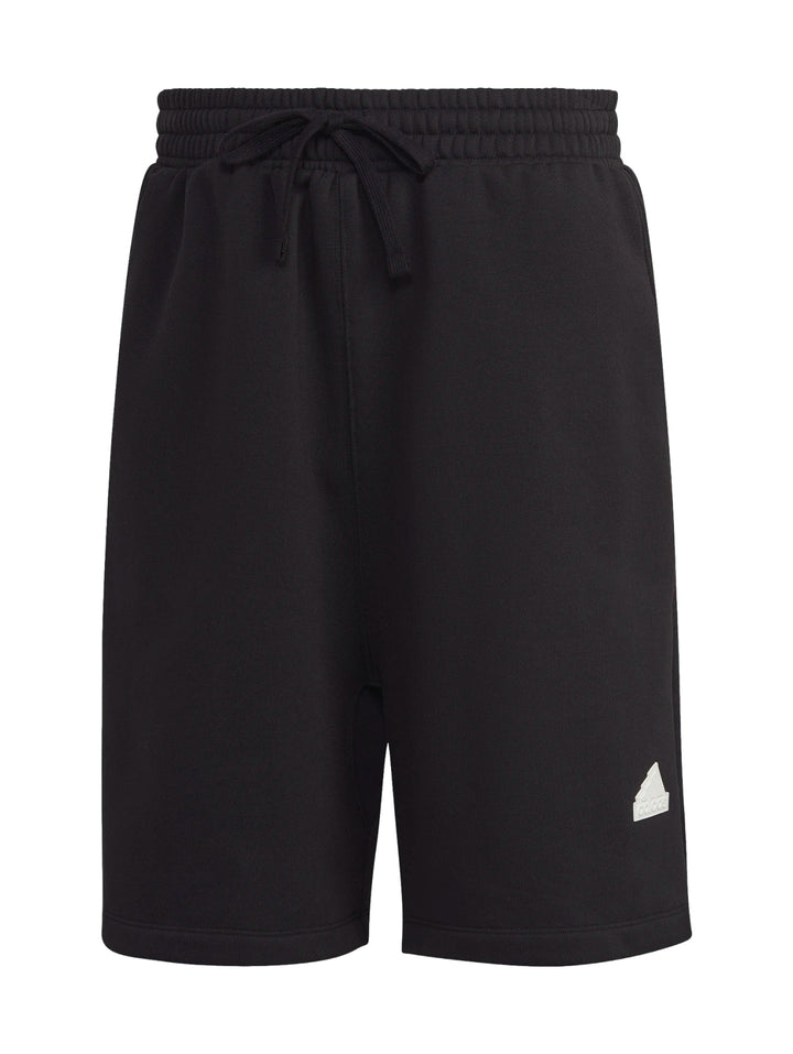 Hombre vistiendo pantalones cortos deportivos Adidas de color negro.