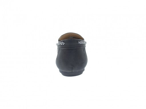 Zapato tipo mocasín color negro con detalles de costuras y cordones blancos en la parte superior.