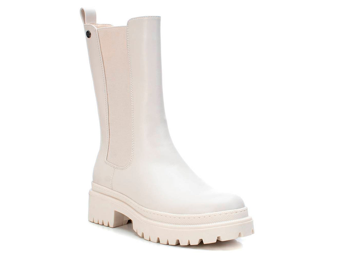 Bota corta color blanco hielo con suela track gruesa y panel elástico lateral.