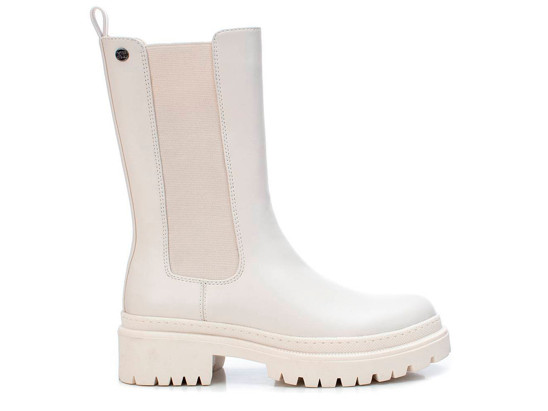 Bota corta color blanco hielo con suela track gruesa y panel elástico lateral.
