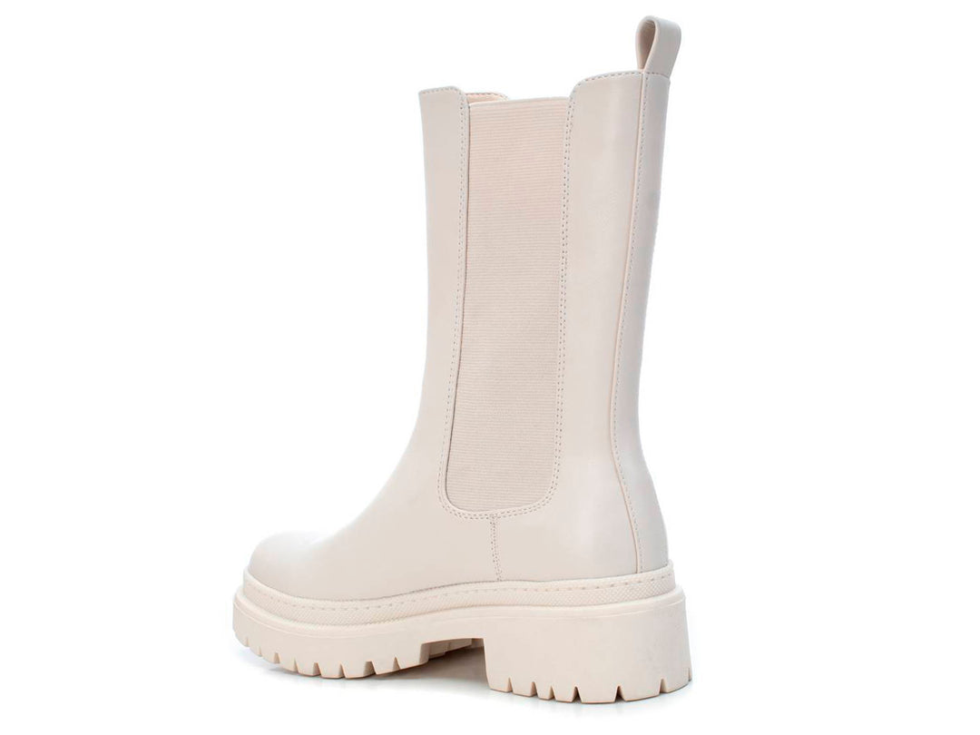 Bota corta color blanco hielo con suela track gruesa y panel elástico lateral.