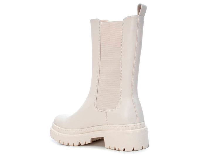 Bota corta color blanco hielo con suela track gruesa y panel elástico lateral.