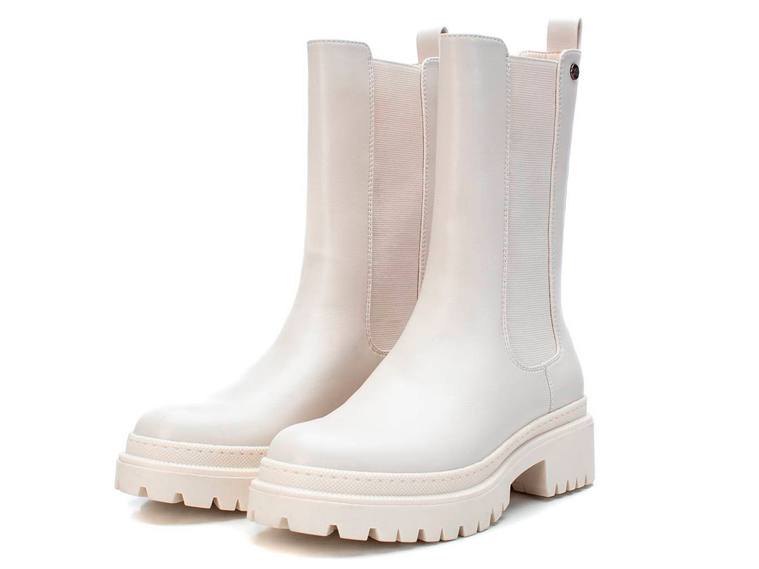 Bota corta color blanco hielo con suela track gruesa y panel elástico lateral.