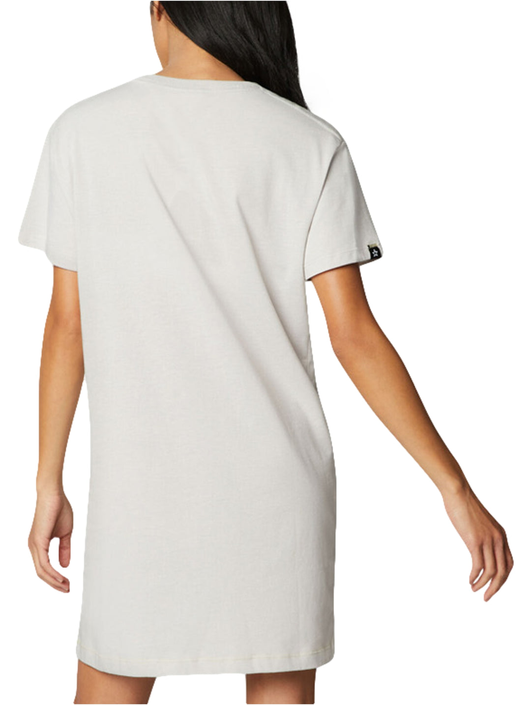 Mujer vistiendo un vestido corto tipo camiseta de color gris claro de la marca Converse.