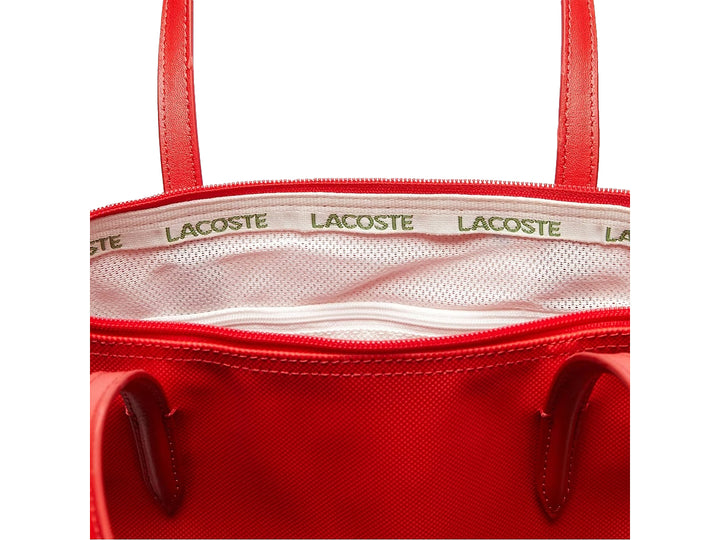 Bolso de hombro Lacoste en color rojo con asas largas y logo frontal metálico sobre fondo blanco.