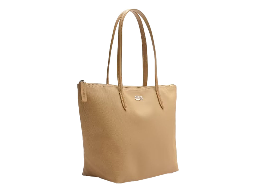 Bolso tote color beige con asas largas y logotipo metálico de Lacoste al frente.