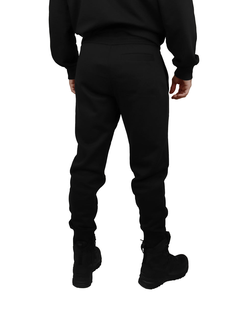 Hombre vistiendo pantalón jogger negro de Calvin Klein con cintura elástica y botas negras.