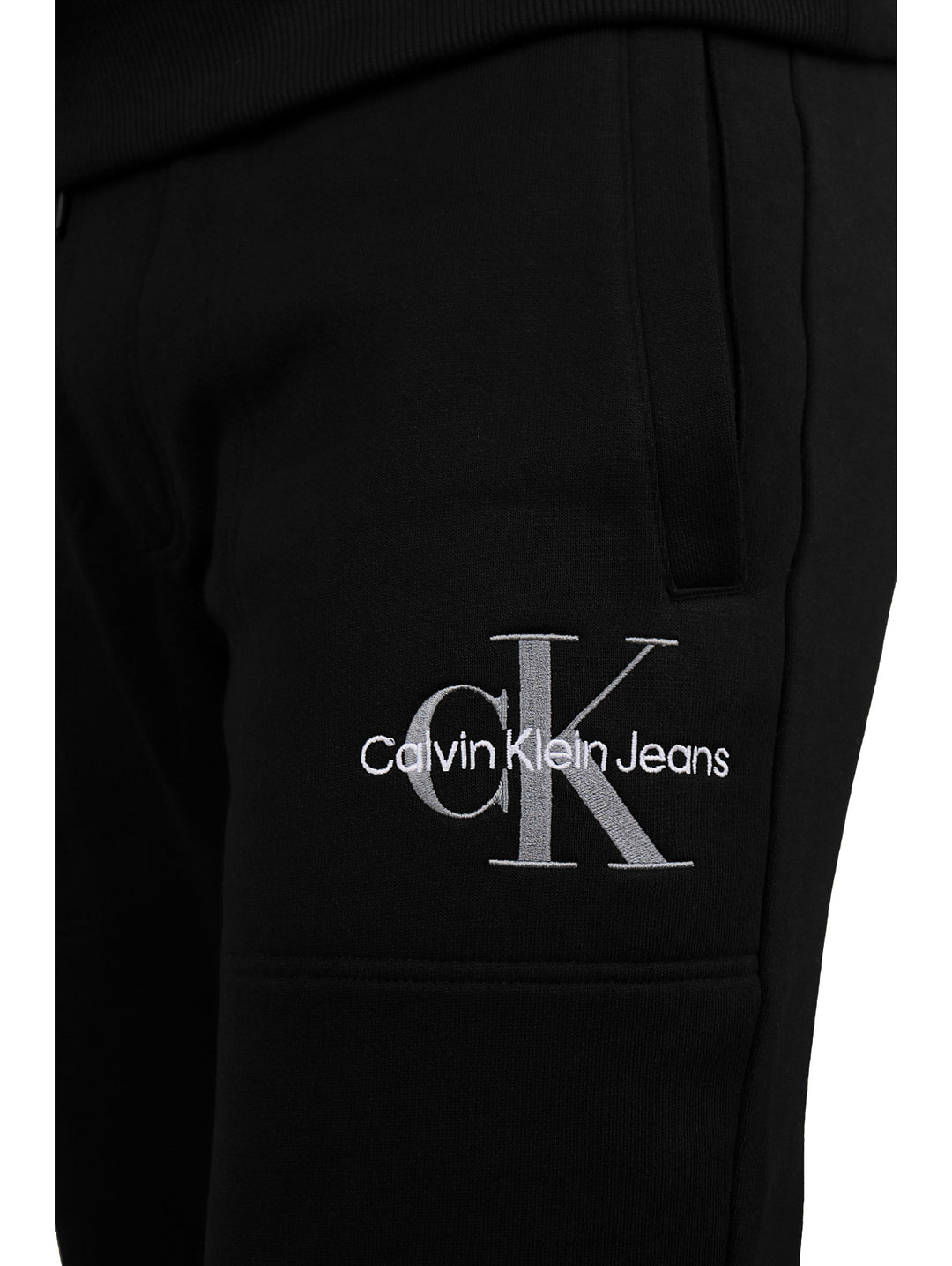 Hombre vistiendo pantalón jogger negro de Calvin Klein con cintura elástica y botas negras.