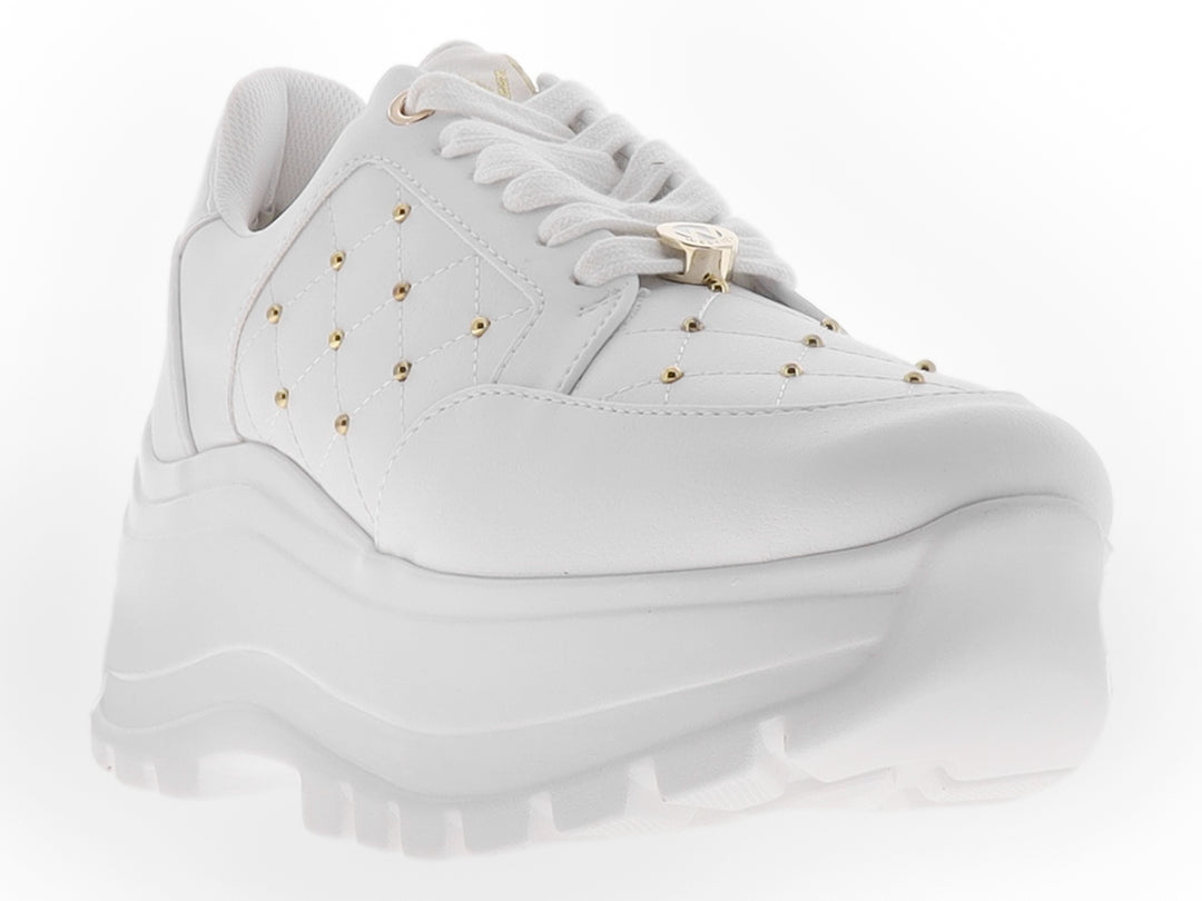 Tenis blancos de plataforma para mujer con detalles de tachuelas doradas y suela gruesa dentada.