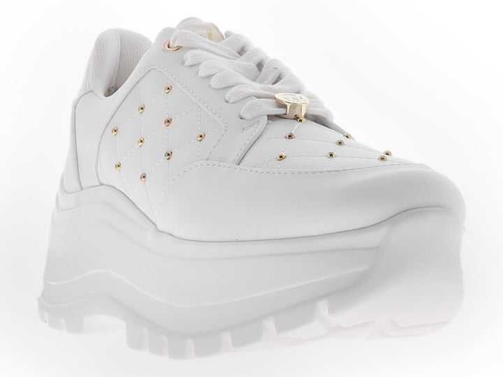 Tenis blancos de plataforma para mujer con detalles de tachuelas doradas y suela gruesa dentada.