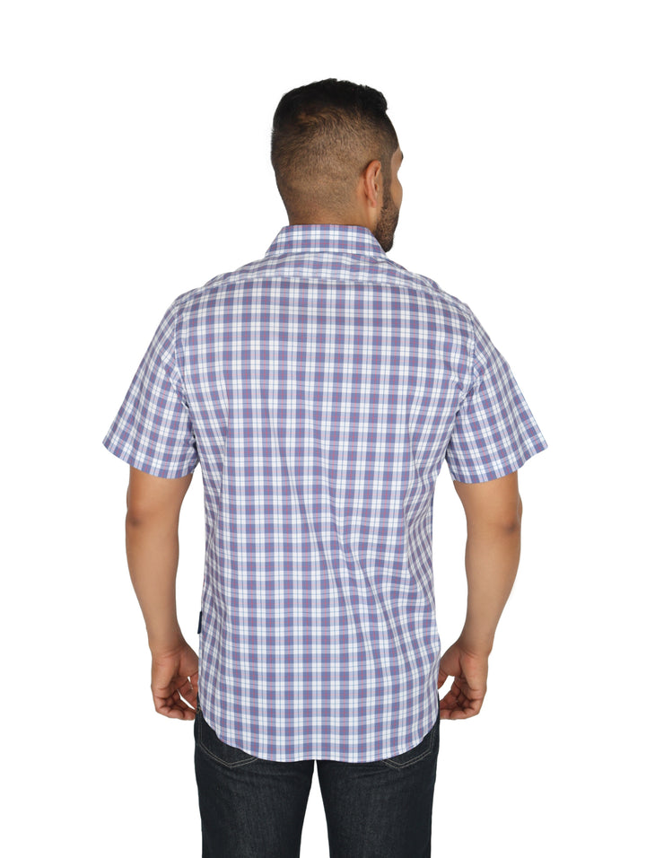 Hombre vistiendo una camisa de manga corta con estampado de cuadros en color azul y blanco.