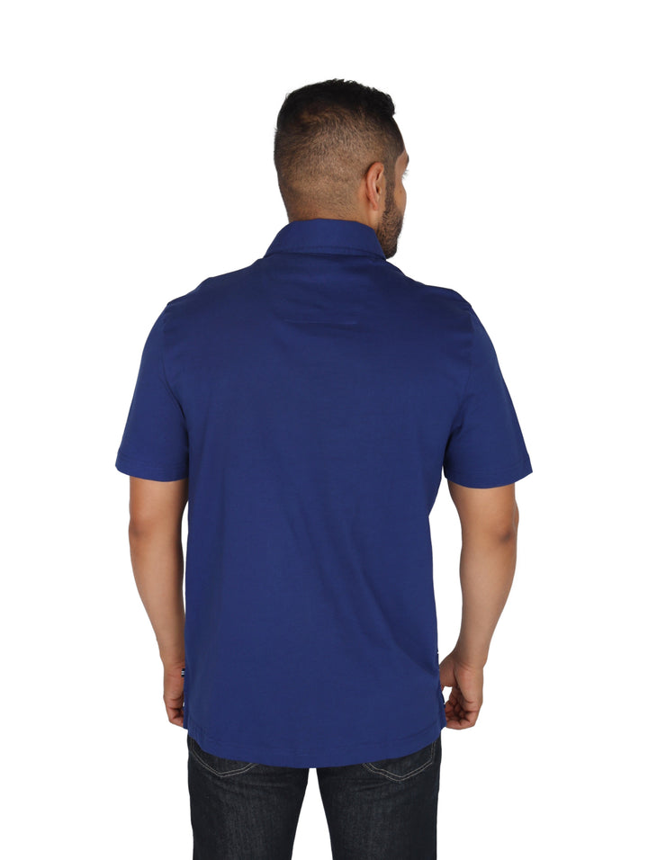 Hombre vistiendo playera polo color navy de Nautica con estampado de veleros blancos.