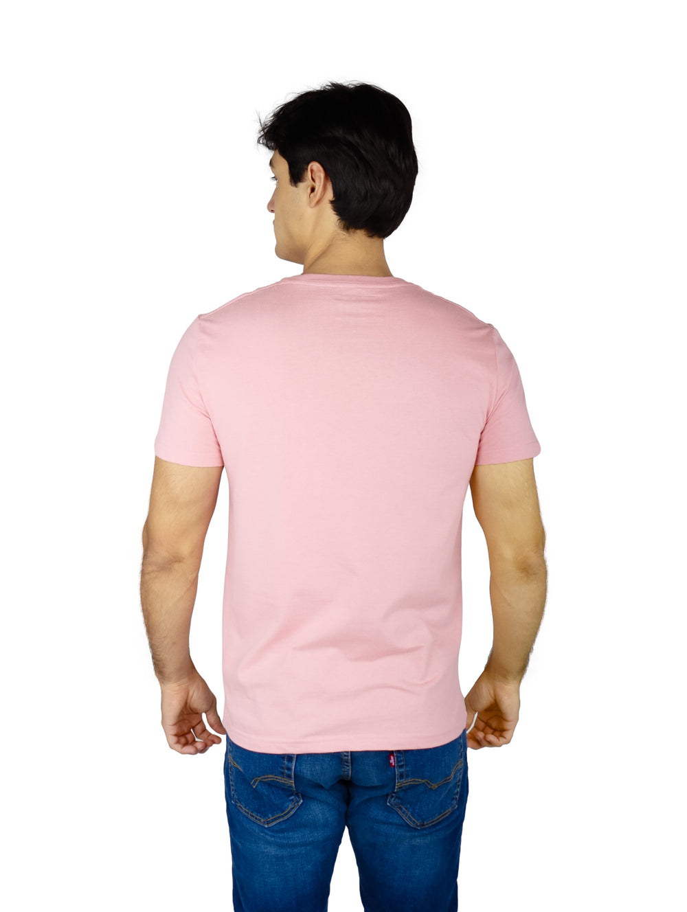 Hombre vistiendo playera Nautica de color rosa con logotipo estampado en el pecho y pantalones mezclilla azules.