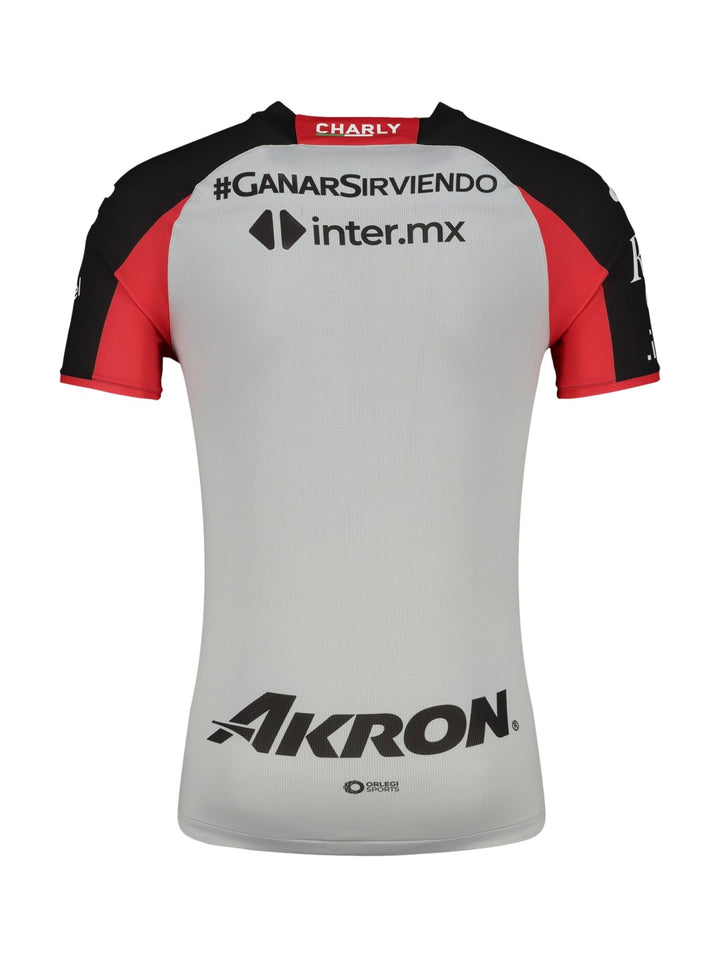 Jersey deportivo Charly color gris con detalles en rojo y negro y logotipos de patrocinadores.