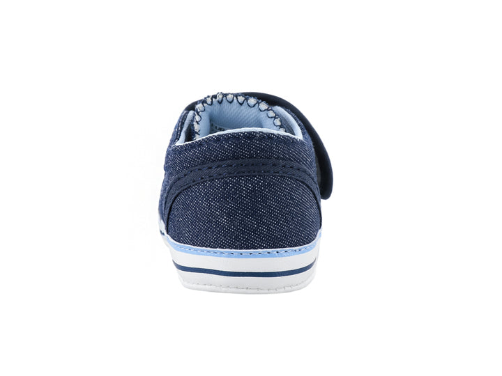 Zapato infantil color azul marino de tela con bordados coloridos y suela blanca.