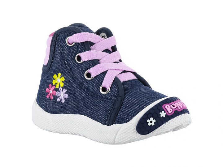 Zapato plano infantil de mezclilla azul con agujetas rosas, flores bordadas y suela blanca.