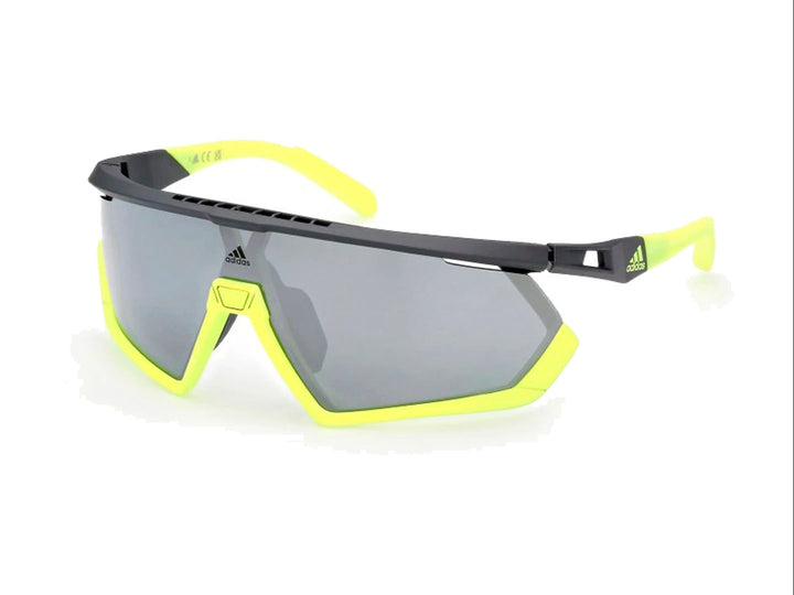 Lentes de sol deportivos Adidas color gris y amarillo con diseño envolvente.