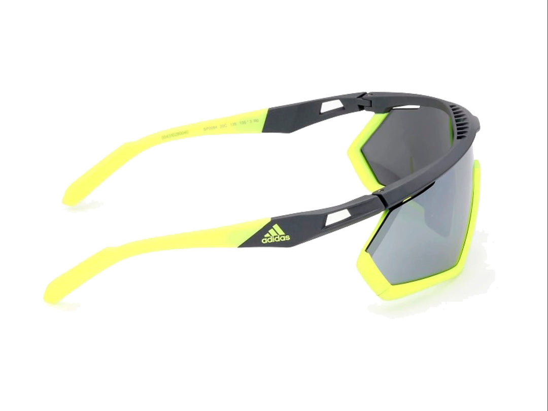 Lentes de sol deportivos Adidas color gris y amarillo con diseño envolvente.
