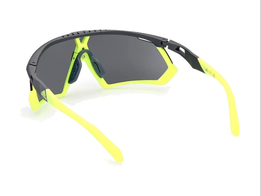 Lentes de sol deportivos Adidas color gris y amarillo con diseño envolvente.