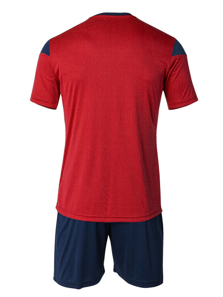 Conjunto deportivo Joma para niño con camiseta roja y shorts azul marino.