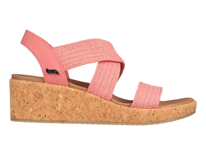 Sandalia Skechers de plataforma en color rosa con tiras tejidas y suela de corcho beige para mujer.