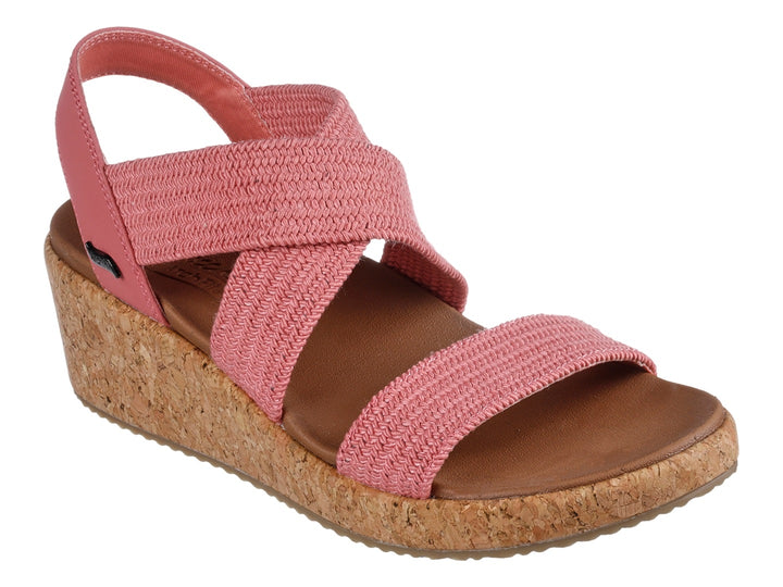 Sandalia Skechers de plataforma en color rosa con tiras tejidas y suela de corcho beige para mujer.