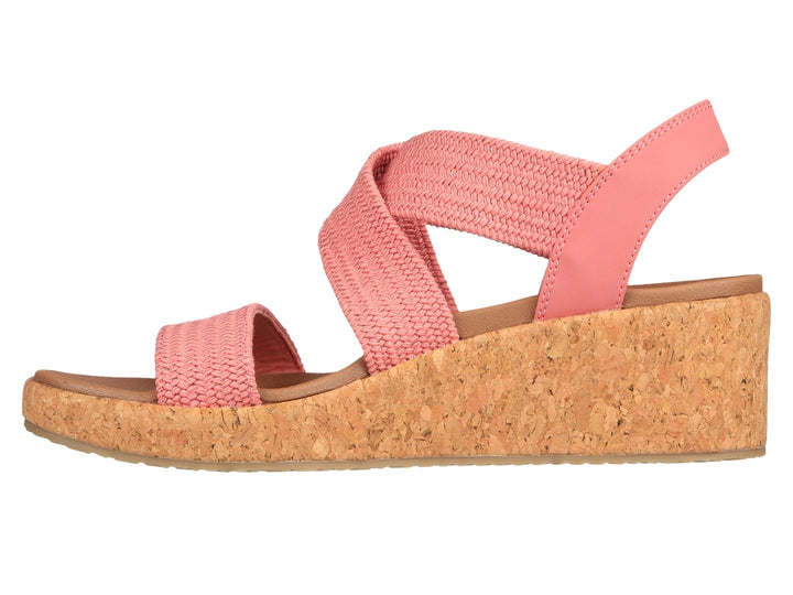 Sandalia Skechers de plataforma en color rosa con tiras tejidas y suela de corcho beige para mujer.