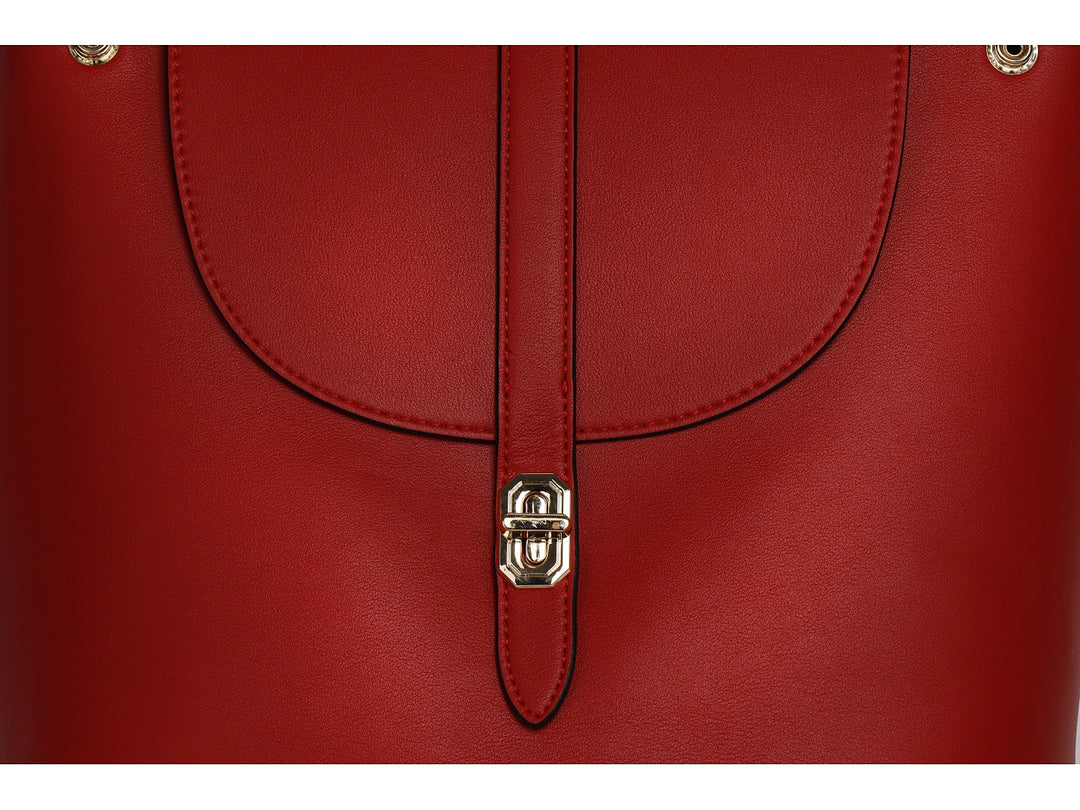 Mochila color rojo de material sintético liso con cierre metálico plateado y asa superior.