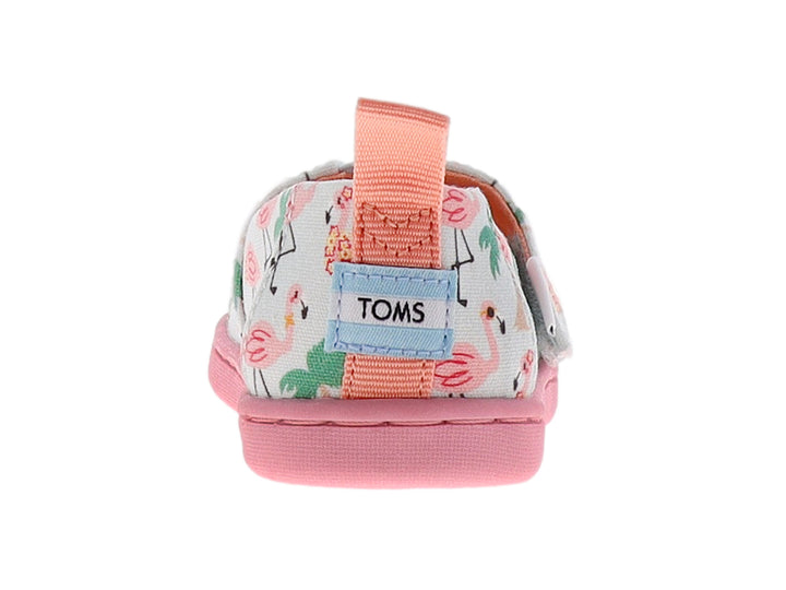 Zapato TOMS infantil azul claro con estampado de flamencos rosas y palmeras, con suela rosa.